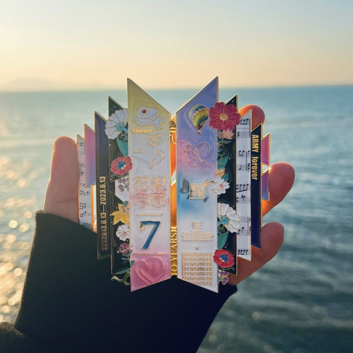 BTS 10th Anniversary Enamel Pin Displayed at Sunset Ocean Beach