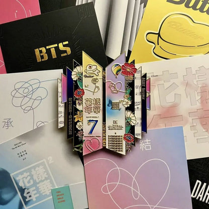 BTS 10th Anniversary Enamel Pin Next to Official BTS Albums and Merch